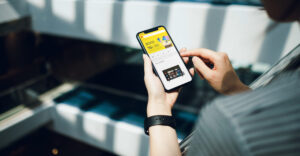 Young woman using smartphone in shopping mall while shopping